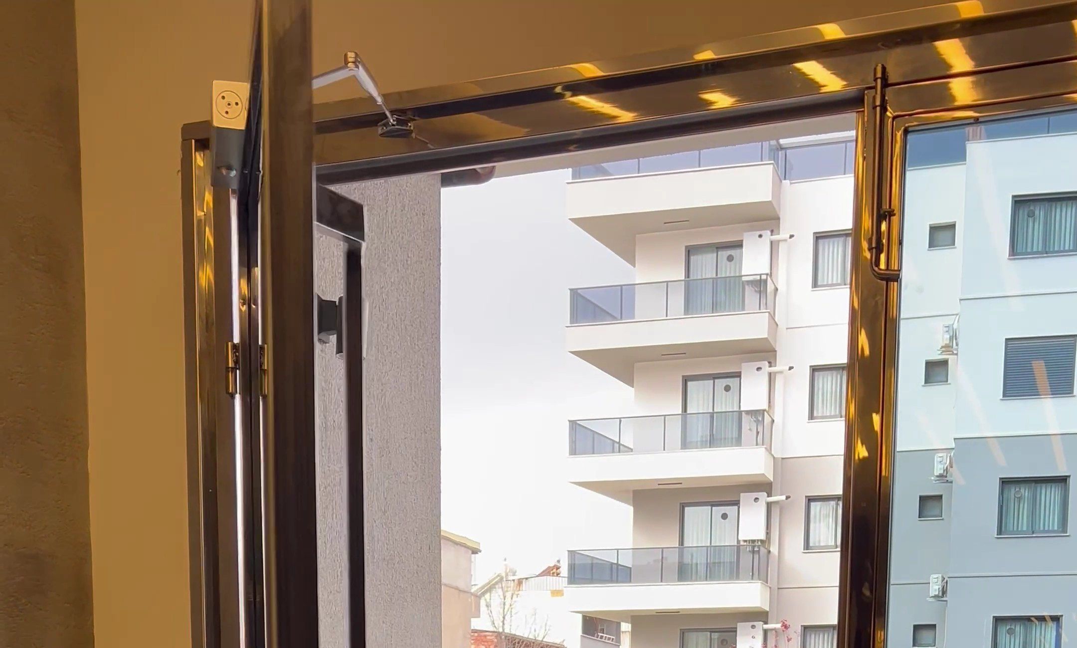 Paslanmaz çerçeveli apartman giriş kapısı ve üstündeki kapı hidroliği